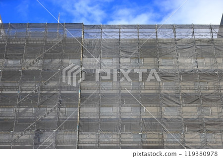 External scaffolding covered with mesh sheets (construction work) External scaffolding covered with mesh sheets (construction work) 119380978