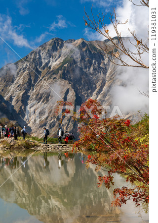 Clouds rising in autumn at Happoike Pond and colorful rowan leaves 119381031