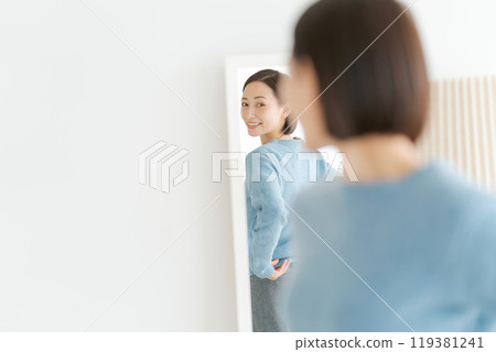 一個女人看著鏡子並做好準備 119381241