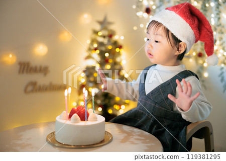 一個 1 歲的孩子看著聖誕蛋糕上的蠟燭 一個 1 歲的孩子看著聖誕蛋糕上的蠟燭 119381295