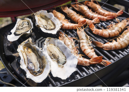 Oysters and shrimp grilled on a gas grill - barbecue image 119381341