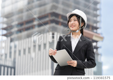 身穿西裝、戴著頭盔、手持平板電腦的年輕女子、施工經理、現場主管、土木工程女孩 (Dobojo) 119381575