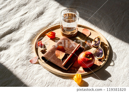 Cozy autumn still life with notebook and fall leaves on wooden tray. 119381820