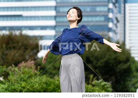 A woman stretching with a cityscape in the background 119382051