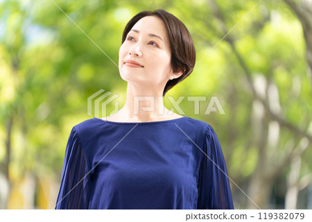 Woman walking along a tree-lined street Woman walking along a tree-lined street 119382079
