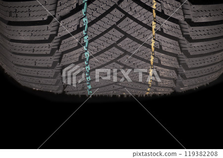 Car tire tread showcasing intricate pattern and colorful markings for enhanced grip and safety 119382208