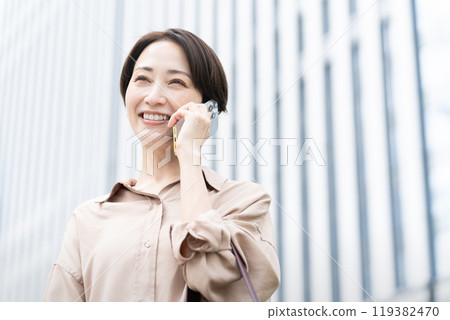 A woman making a phone call in a city A woman making a phone call in a city 119382470