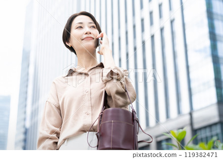 A woman making a phone call in a city A woman making a phone call in a city 119382471