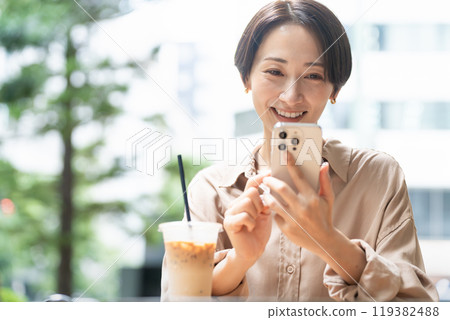 一位女士在咖啡館操作智慧型手機 119382488
