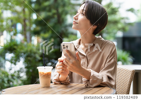 一位女士在咖啡館操作智慧型手機 119382489