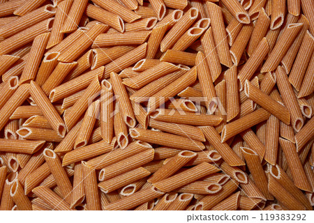 Uncooked Whole Grain Penne Rigate Pasta Background Uncooked Whole Grain Penne Rigate Pasta Background 119383292