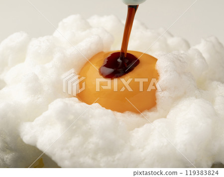 Pour soy sauce onto the egg yolk on top of the whipped egg white placed on rice. 119383824
