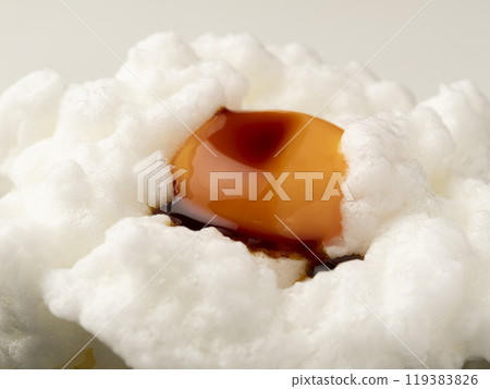 Pour soy sauce onto the egg yolk on top of the whipped egg white placed on rice. Pour soy sauce onto the egg yolk on top of the whipped egg white placed on rice. 119383826