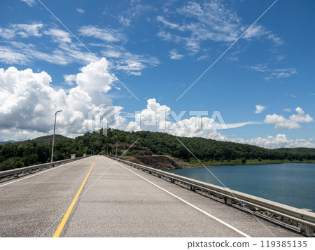 The asphalt road along the large earth dam. 119385135