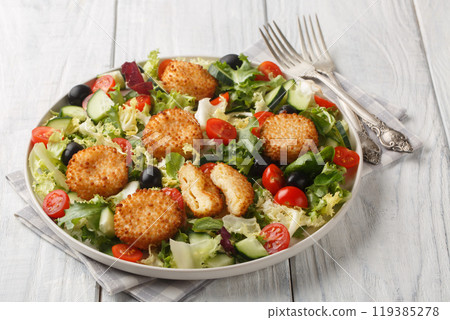 Breakfast salad of fried cheese balls with tomatoes, cucumber, olives and mixed lettuce close-up in a plate. Horizontal Breakfast salad of fried cheese balls with tomatoes, cucumber, olives and mixed lettuce close-up in a plate. Horizontal 119385278