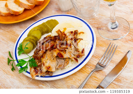 Lunch served on plate - roasted pork chop with mushed potato and slices of cucumber pickles Lunch served on plate - roasted pork chop with mushed potato and slices of cucumber pickles 119385319