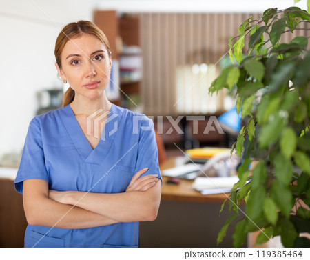 Portrait of a young woman therapist in a clinic, standing in the office Portrait of a young woman therapist in a clinic, standing in the office 119385464