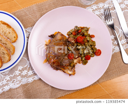 Grilled pork cheek with stewed beans and carrots 119385474