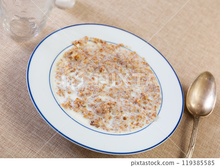 There is portion of freshly prepared milk oatmeal porridge in plate There is portion of freshly prepared milk oatmeal porridge in plate 119385585