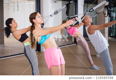 People training trx pilates at group class People training trx pilates at group class 119385599