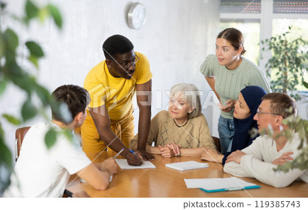Group of multinational people discussing documents at table 119385743