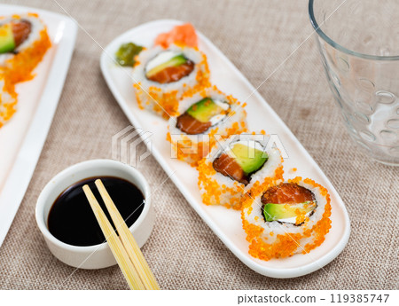 Japanese dish california roll masago with salmon, avocado, cheese and caviar closeup Japanese dish california roll masago with salmon, avocado, cheese and caviar closeup 119385747
