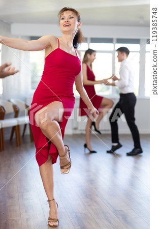 Smiling young girl in elegant clothes dancing in couple with African american man latin dance, energetic and fast jive in dance salon during celebration or party Smiling young girl in elegant clothes dancing in couple with African american man latin dance, energetic and fast jive in dance salon during celebration or party 119385748