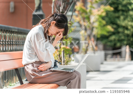 Crying/troubled business woman on a park bench (stress, trouble, shock, depressed) 119385946