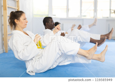 Group of multiethnic people doing abdominal exercises 119385949