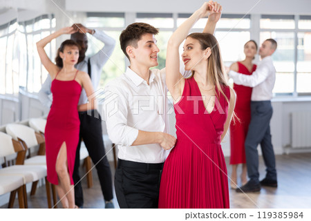 Young man and girl dancing waltz in couple during lesson at studio Young man and girl dancing waltz in couple during lesson at studio 119385984