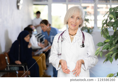 Portrait of friendly woman doctor in clinic lobby Portrait of friendly woman doctor in clinic lobby 119386160