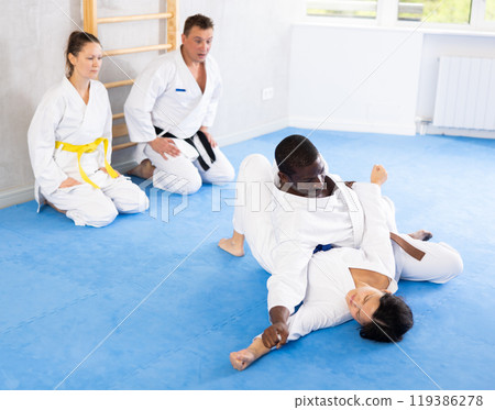 Adult man and young woman training judo techniques Adult man and young woman training judo techniques 119386278