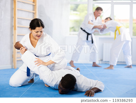 Man and woman practicing judo together on sports mats 119386293