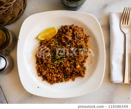Plate is filled with paella made according to Spanish recipe from rice cereals, seafood, and chicken Plate is filled with paella made according to Spanish recipe from rice cereals, seafood, and chicken 119386349