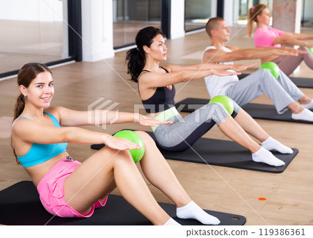 People doing crunches with pilates ball 119386361