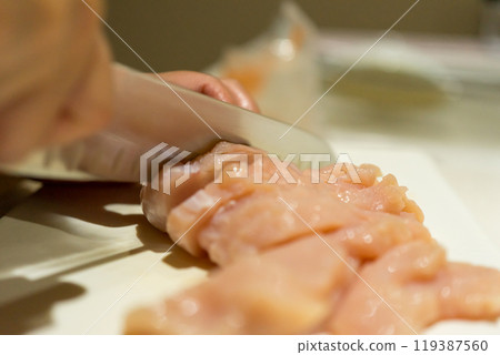 Housewife cutting chicken breast 119387560