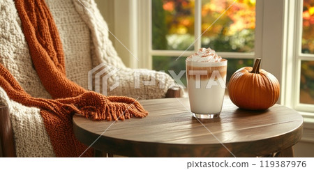 Cozy autumn scene with pumpkin spice latte and blanket by window 119387976