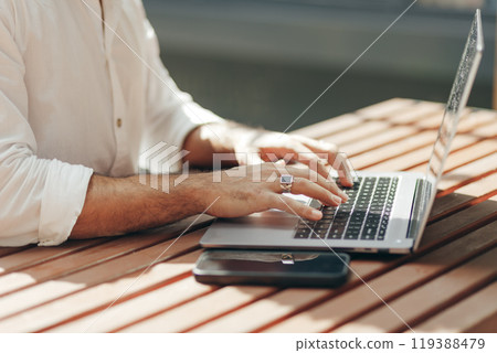 Freelancer Arabian man working with laptop in outdoors. Close up view on hands Freelancer Arabian man working with laptop in outdoors. Close up view on hands 119388479