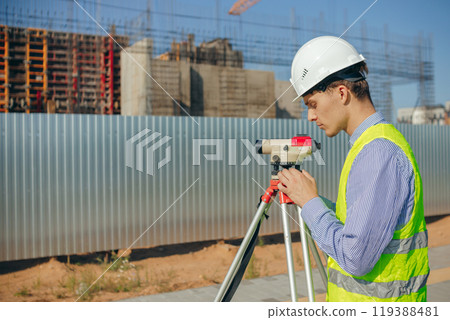 Surveyor engineer adjust optical level on construction site 119388481
