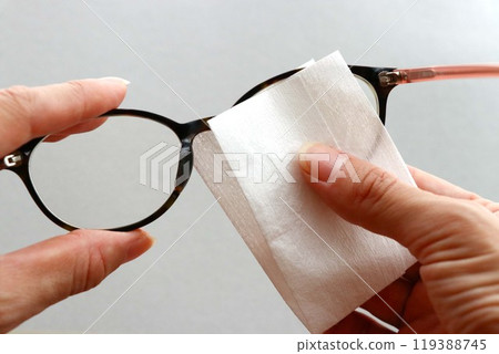 Wiping the lenses of glasses with a glasses cloth 119388745