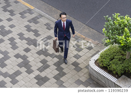 Aerial view of a middle-aged businessman walking in the city 119390239