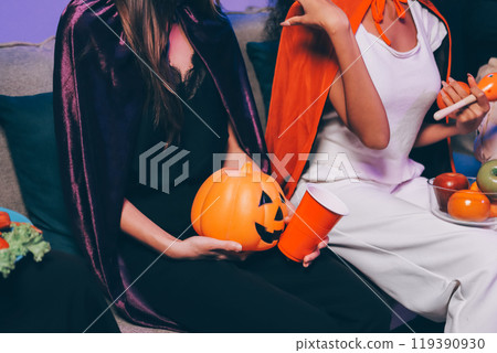 Joyful office Halloween party with coworkers in costumes, celebrating with drinks and laughter, fostering teamwork and festive spirit 119390930