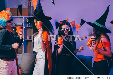 Joyful office Halloween party with coworkers in costumes, celebrating with drinks and laughter, fostering teamwork and festive spirit 119390954
