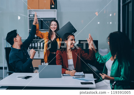 Young corporate employees sitting in office looking at laptop screen reading good news excited happy team diverse people celebrating victory win command success excellent result professional teamwork 119391005