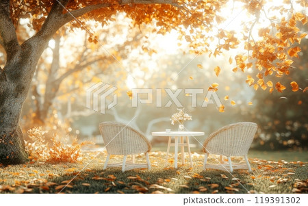a peaceful autumn garden with a set of simple wicker chairs around a small white table 119391302