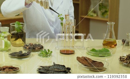 Creative advertising template for natural extract shampoo product in laboratory scene, a scientist is putting a herb into test tube, which placed on yellow table with many other natural ingredients Creative advertising template for natural extract shampoo product in laboratory scene, a scientist is putting a herb into test tube, which placed on yellow table with many other natural ingredients 119392358