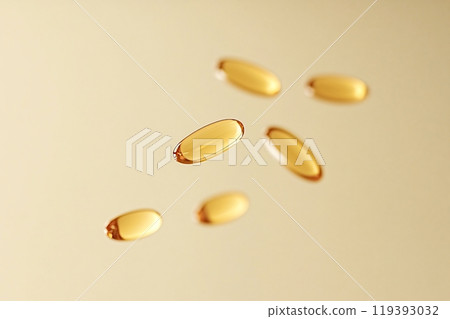 Golden vitamin pills floating on a soft gold background 119393032