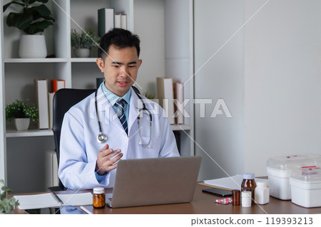 Male Doctor Engaged in Medical Studies for Advancing Health Care Practices in a Modern Clinical Setting 119393213