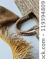 Relaxed lifestyle on the coast. A straw bag and hat in natural colors with palm branches. Summer vibes. 119394809