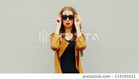 Fashion portrait elegant woman wearing a sunglasses jacket over grey background Fashion portrait elegant woman wearing a sunglasses jacket over grey background 119395012